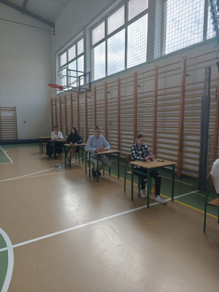 uczniowie siedzący w ławce czekając na egzamin