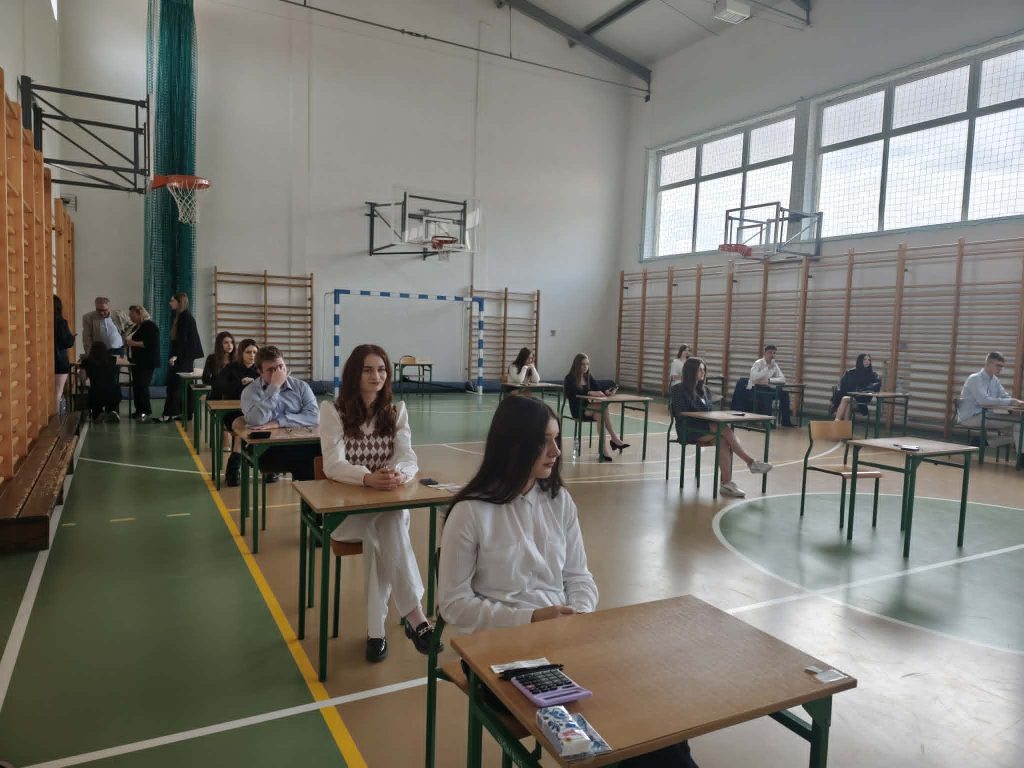 uczniowie siedzący w ławce czekając na egzamin