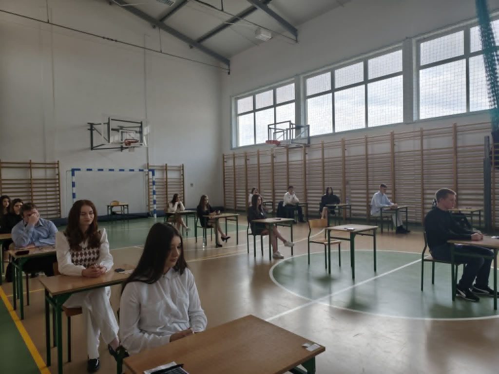 uczniowie siedzący w ławce czekając na egzamin