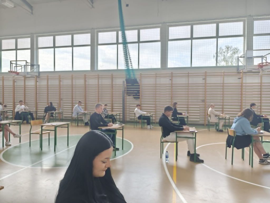 uczniowie siedzący w ławce czekając na egzamin