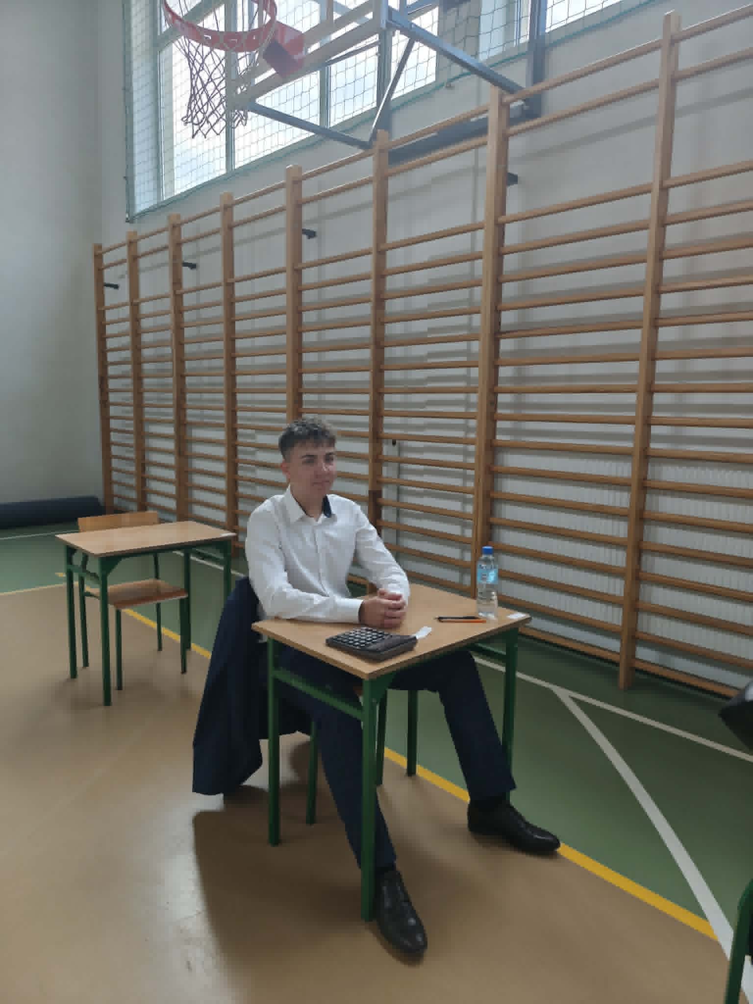uczniowie siedzący w ławce czekając na egzamin